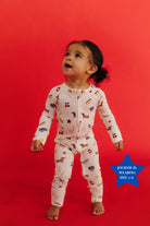 baby standing on red plain background with 4th of july icon print