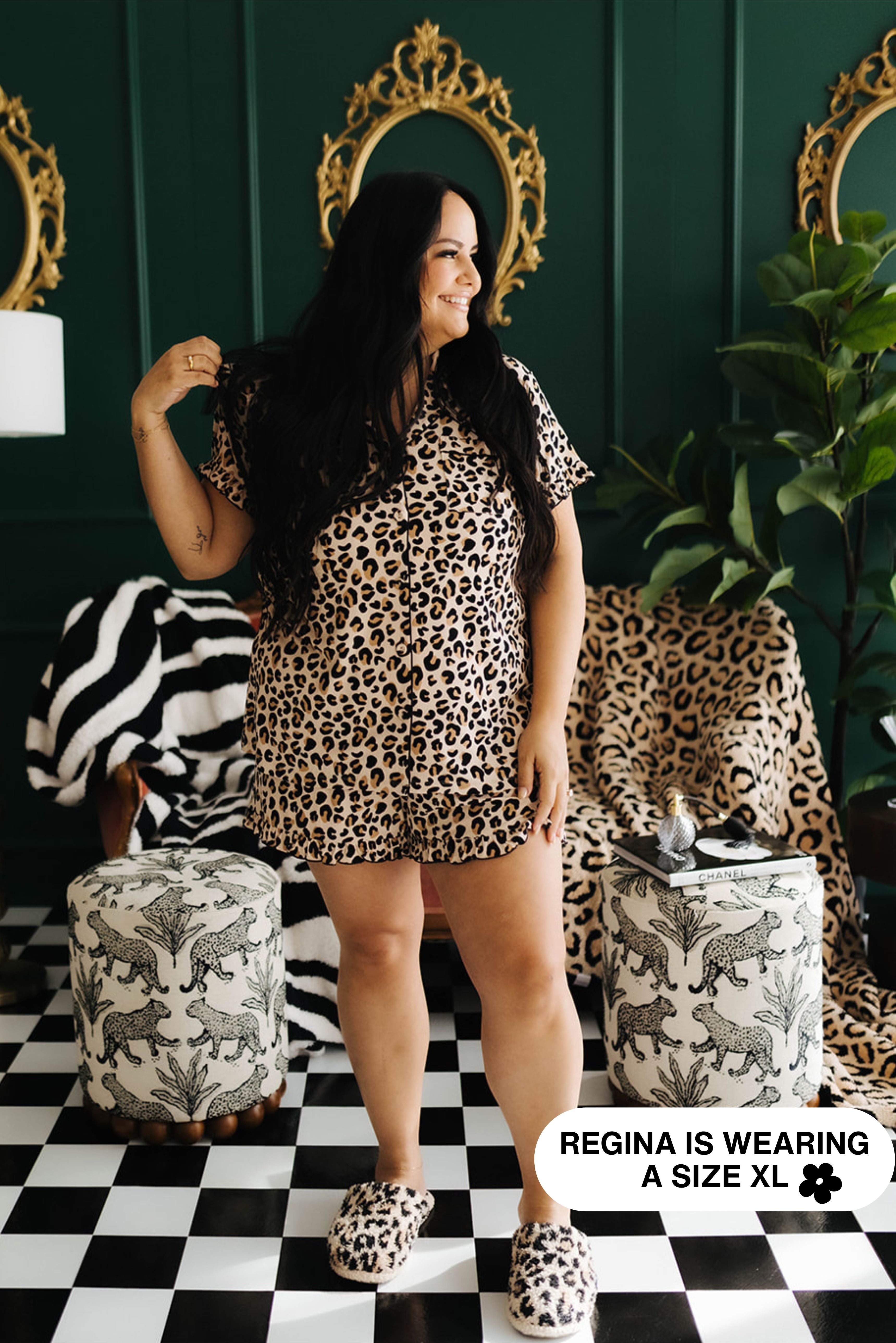 Woman wearing leopard print pjs in a stylish room with green walls and checkered floor.