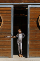 Sizing photo: Kolly in 7/8 wearing brown and cream striped kids pajama set.