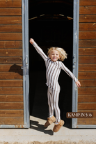 Sizing photo: Kampin in 5/6 wearing brown and cream striped kids pajama set.