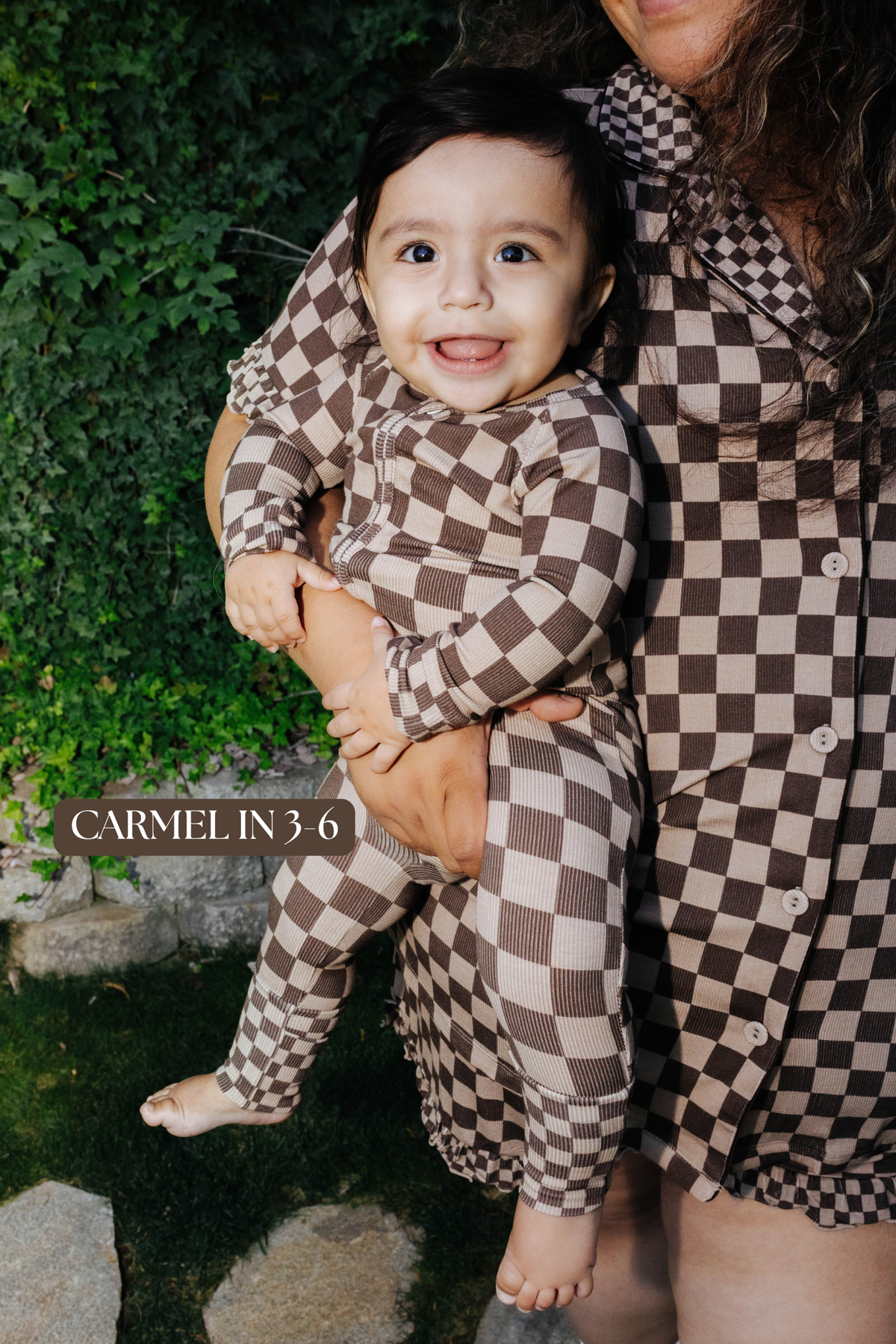 Sizing photo: Carmel in 3-6 months wearing brown check baby zip pajamas.