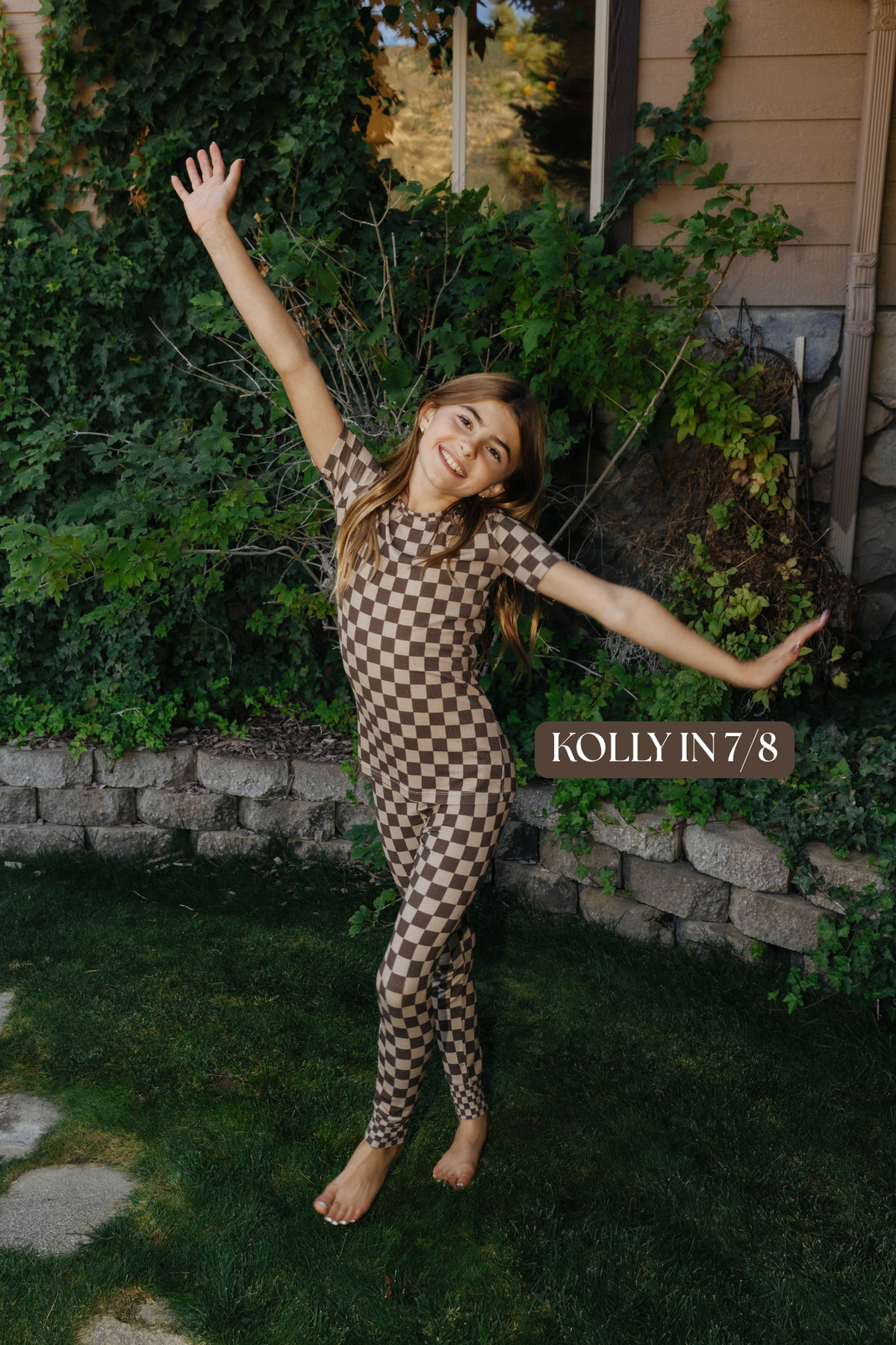 Sizing photo: Kolly in 7/8 wearing brown check kids pajama set.