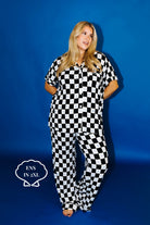 Person wearing a black and white checkered outfit against a blue background