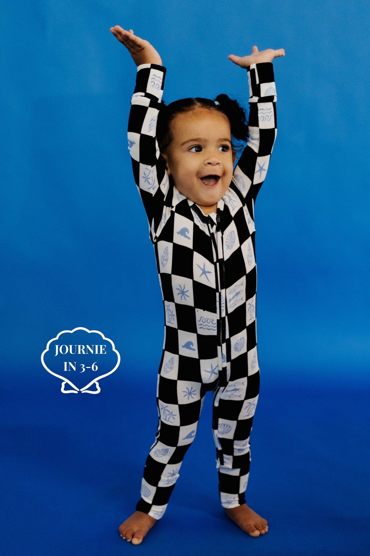 Child wearing a black and white checkered onesie size 3-6 months