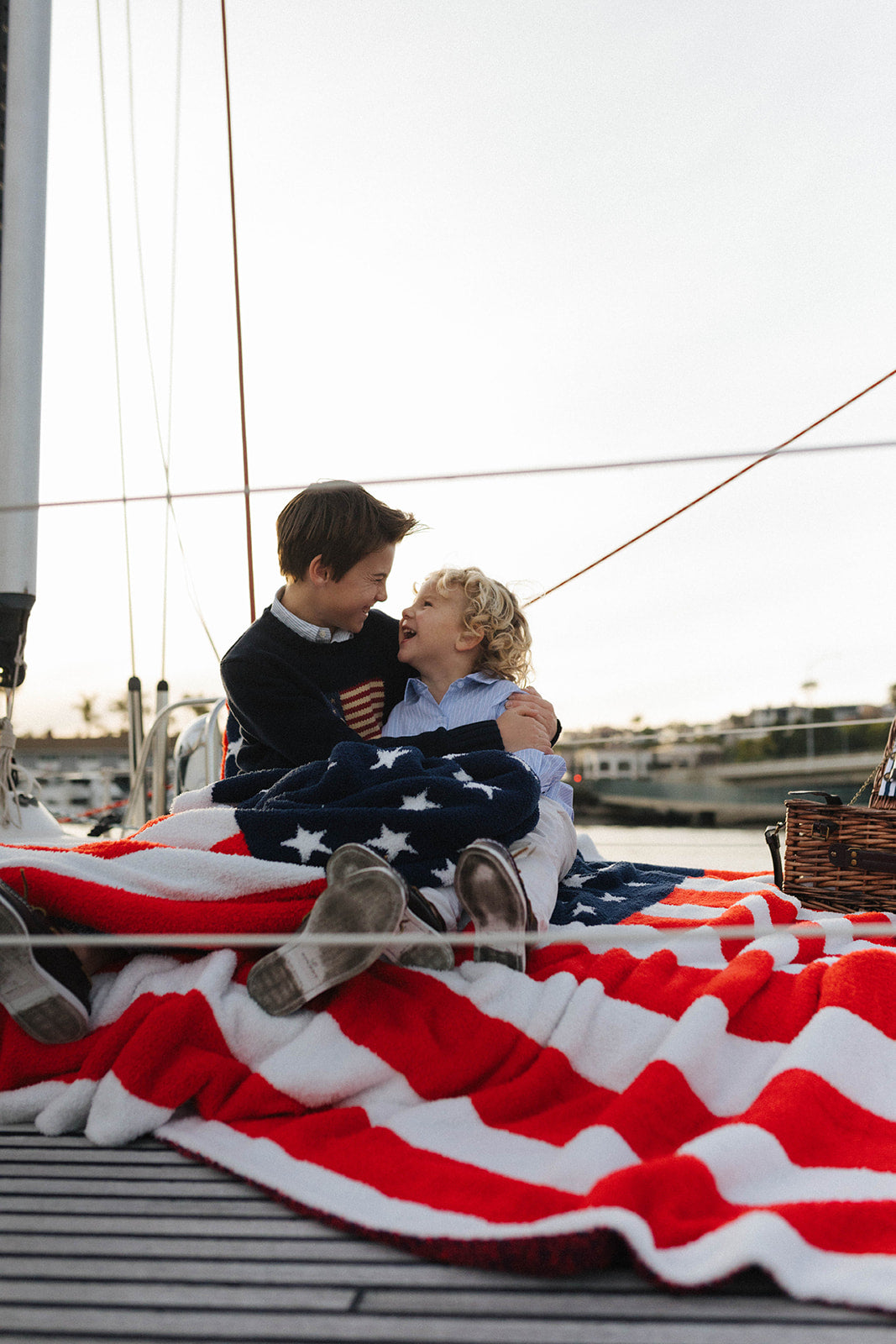 boys cuddling with the blankets on a boat 