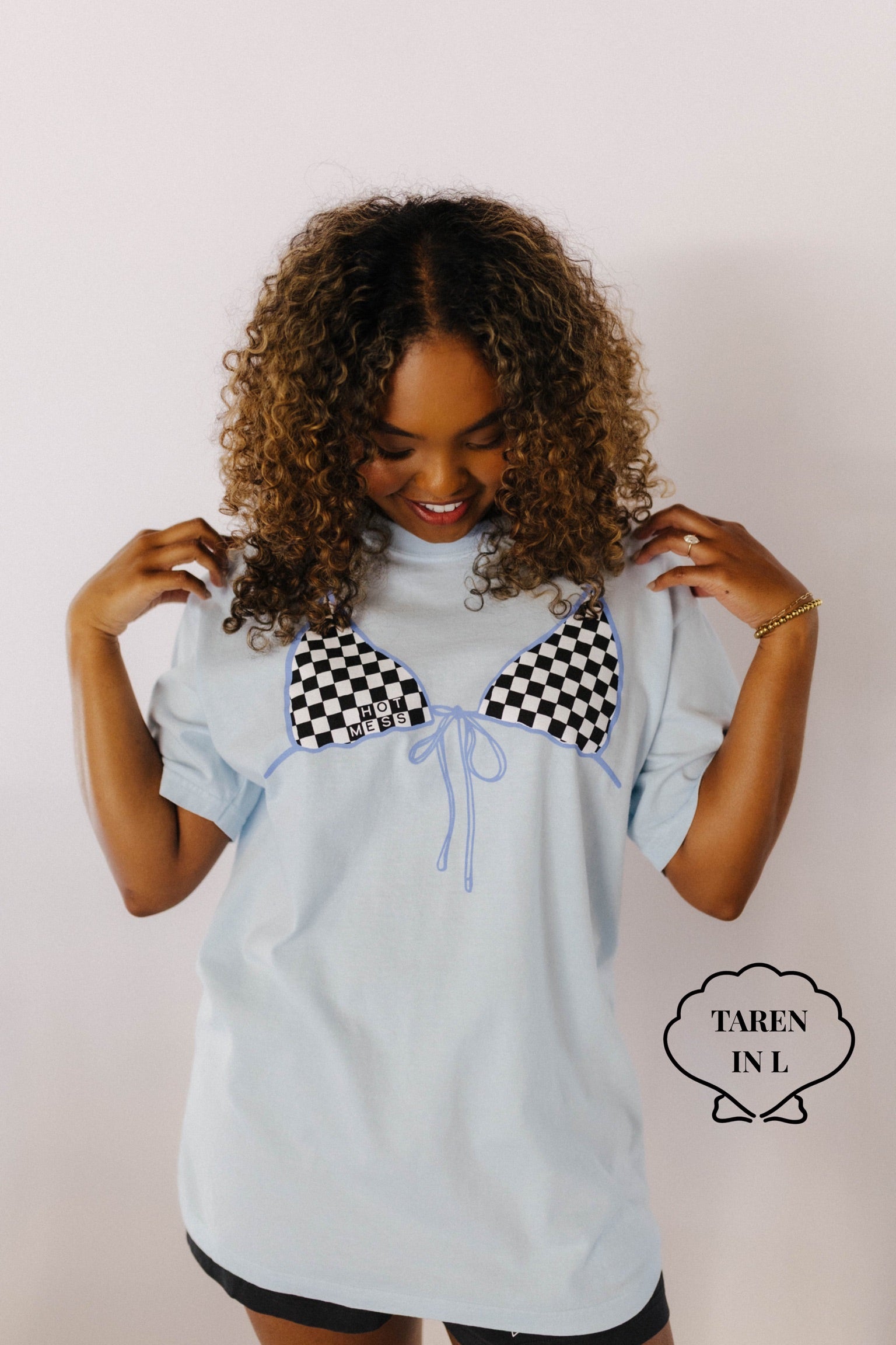 Woman wearing a light blue tee with a check bikini design