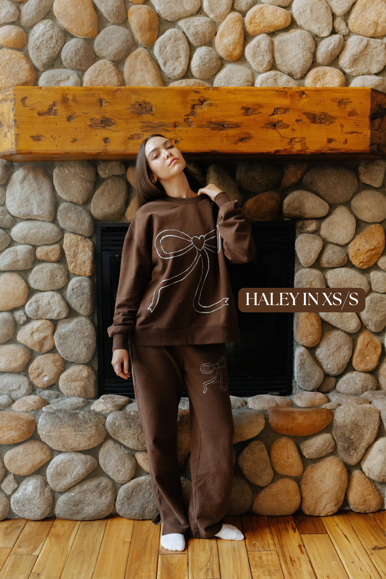 Sizing photo: Haley in XS/S wearing brown sweatshirt with blue bow and matching sweatpants.