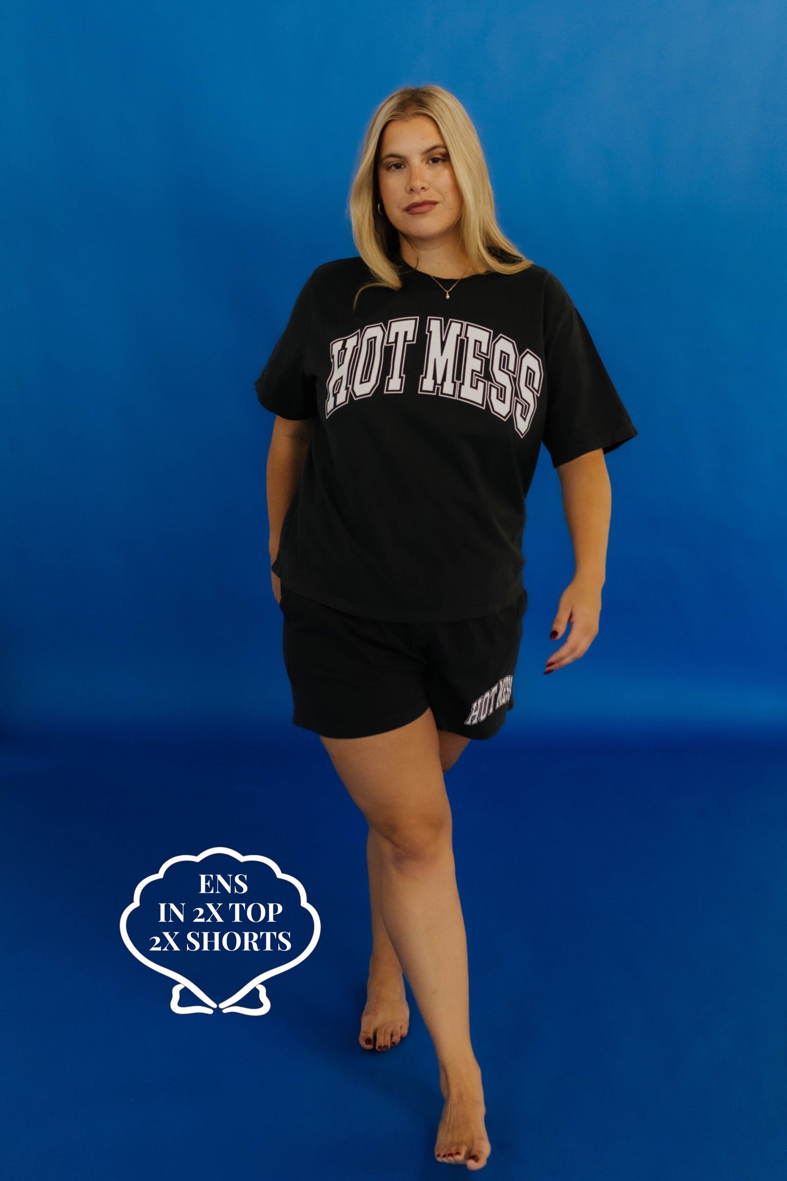 Woman wearing a black 'HOT MESS' t-shirt and shorts on a blue background size 2x