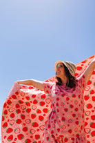Krista holding the strabwerry outdoor quillow into the air with her matching strawberry pjs 