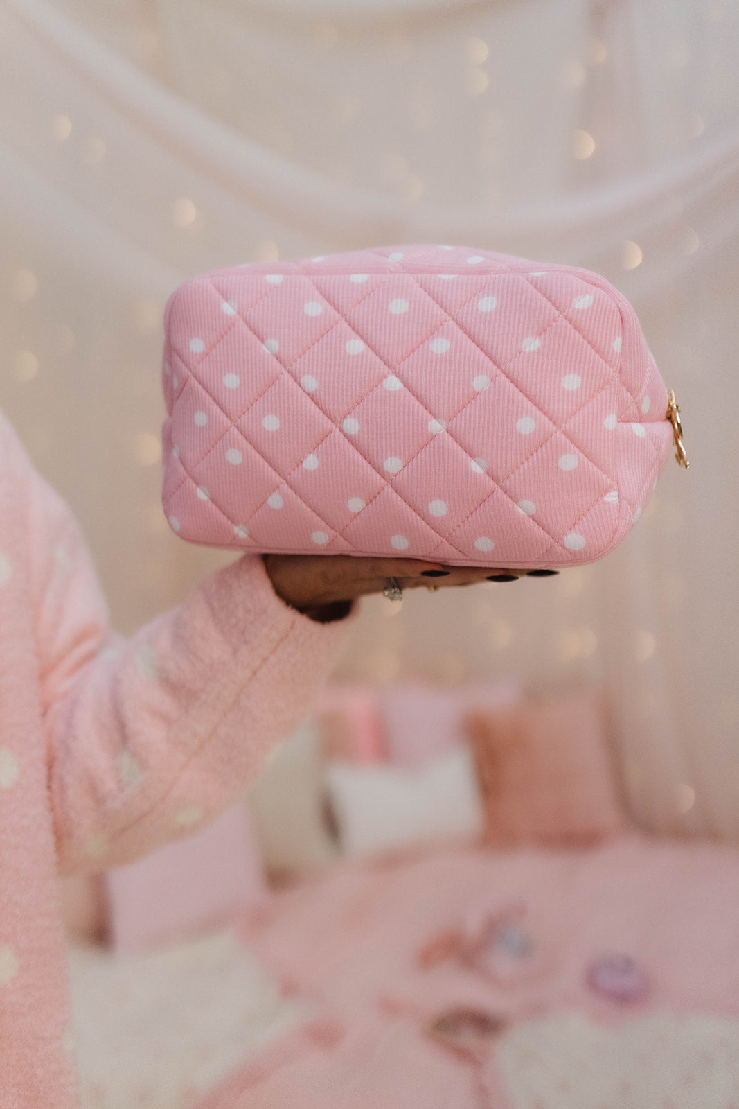 Pink polka dot bag held by a person with a blurred background