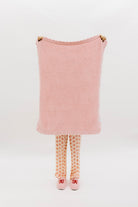 Pink textured blanket held up on white background