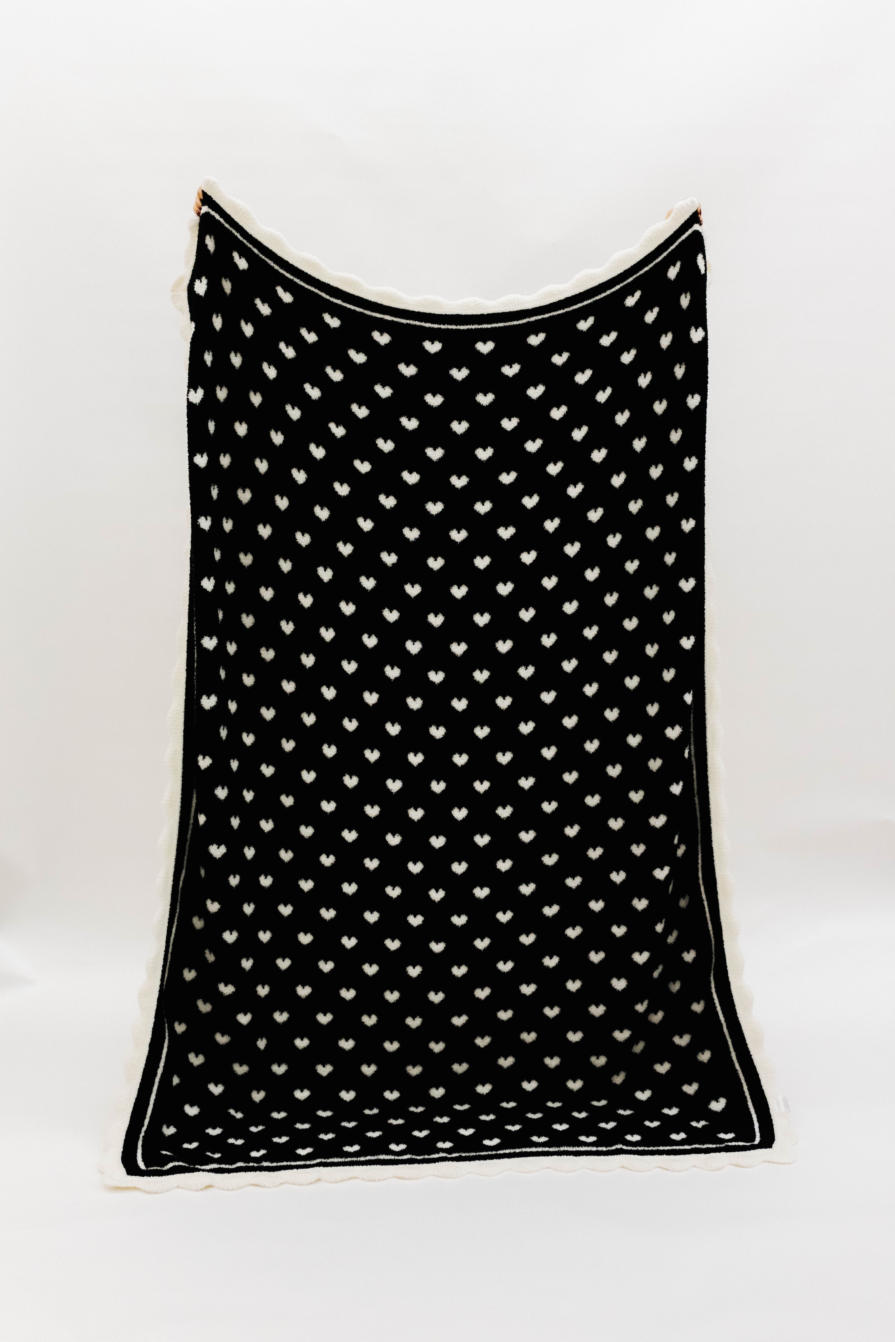 Black blanket with white hearts and scalloped edges