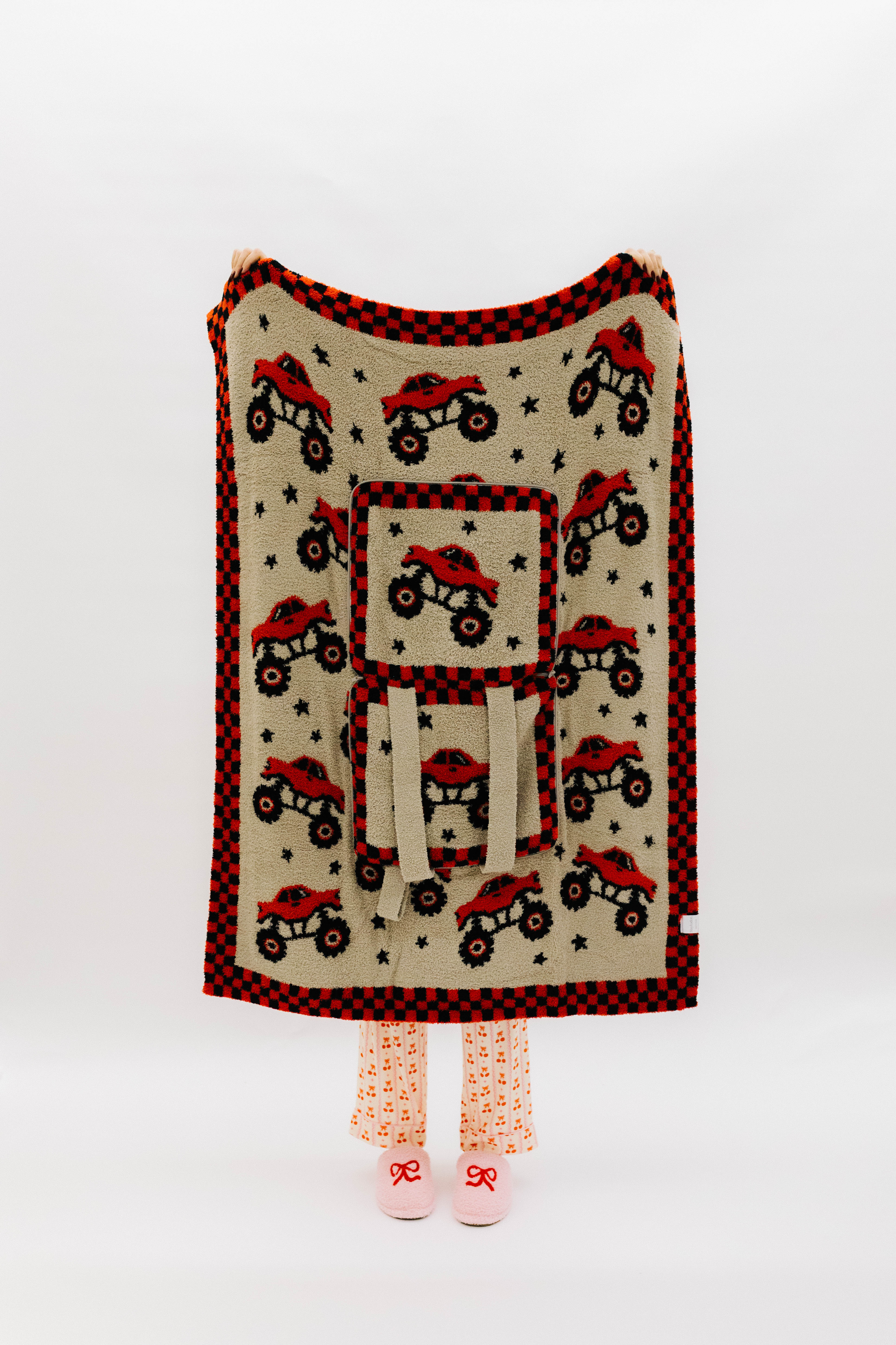 Monster truck quillow front, fully folded out and hanging to see the full design on trucks, stars, and check border