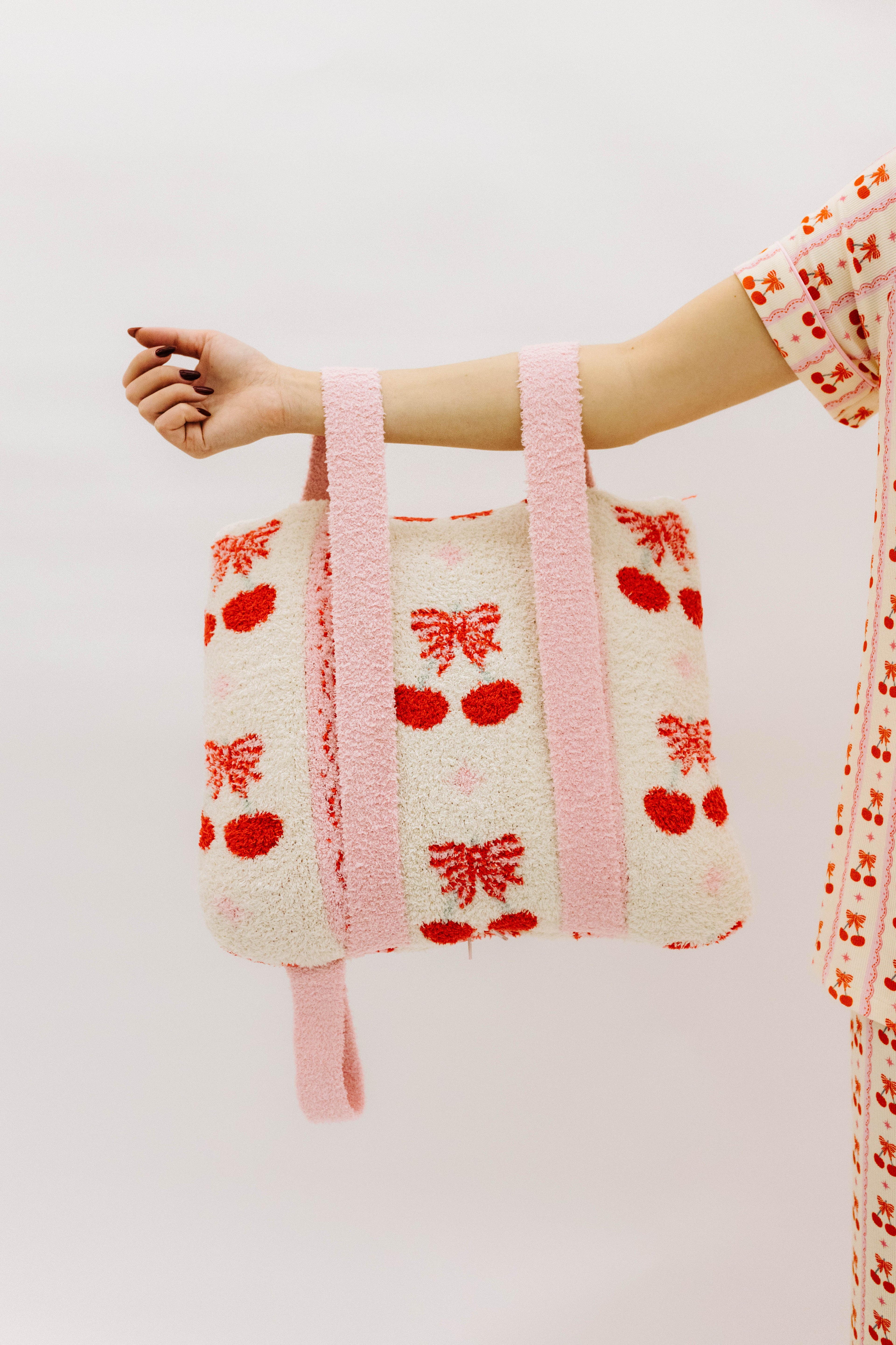 Holding the cherry quillow by the backpack straps
