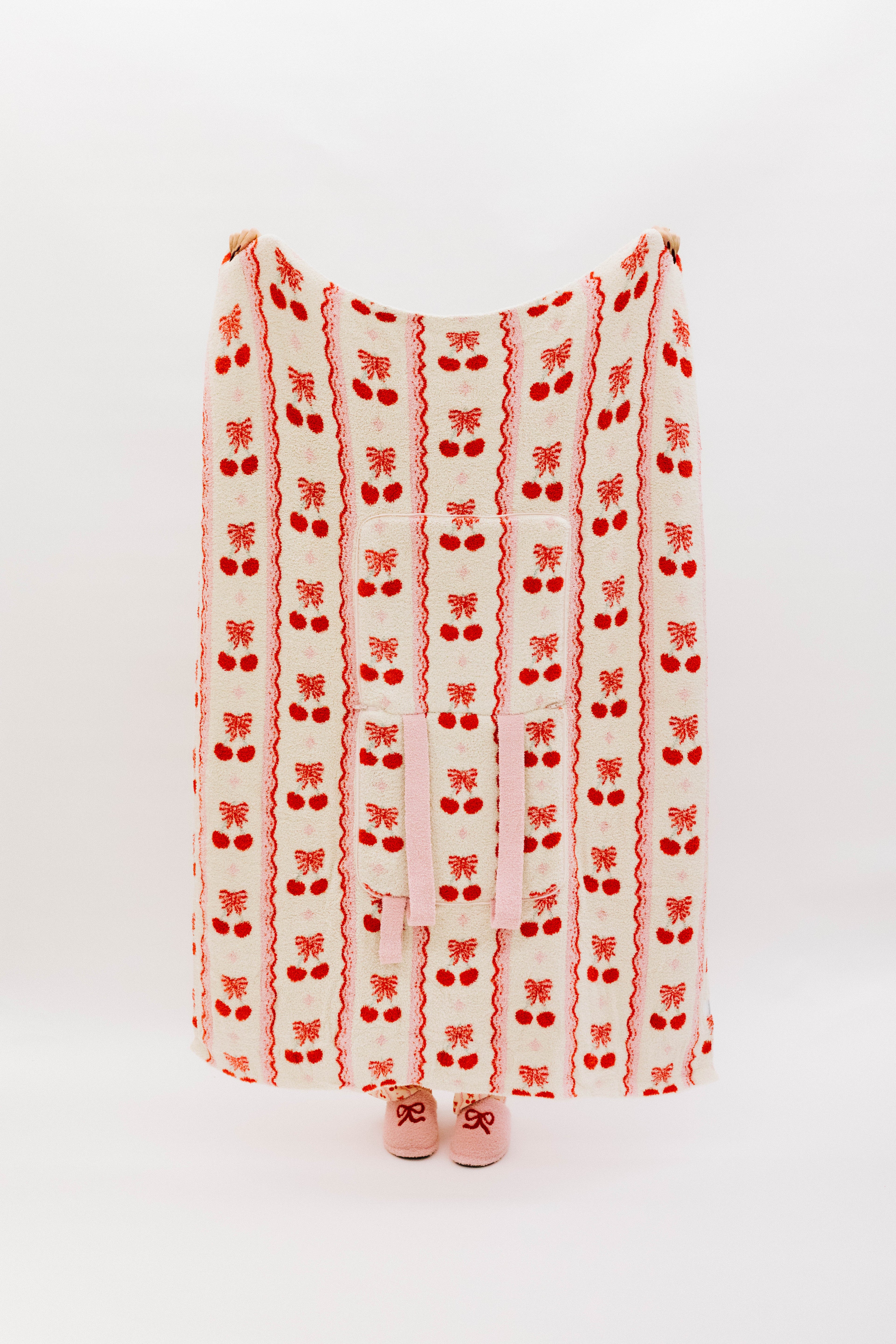 Holding the cherry bow quillow so it shows the full size (front side)