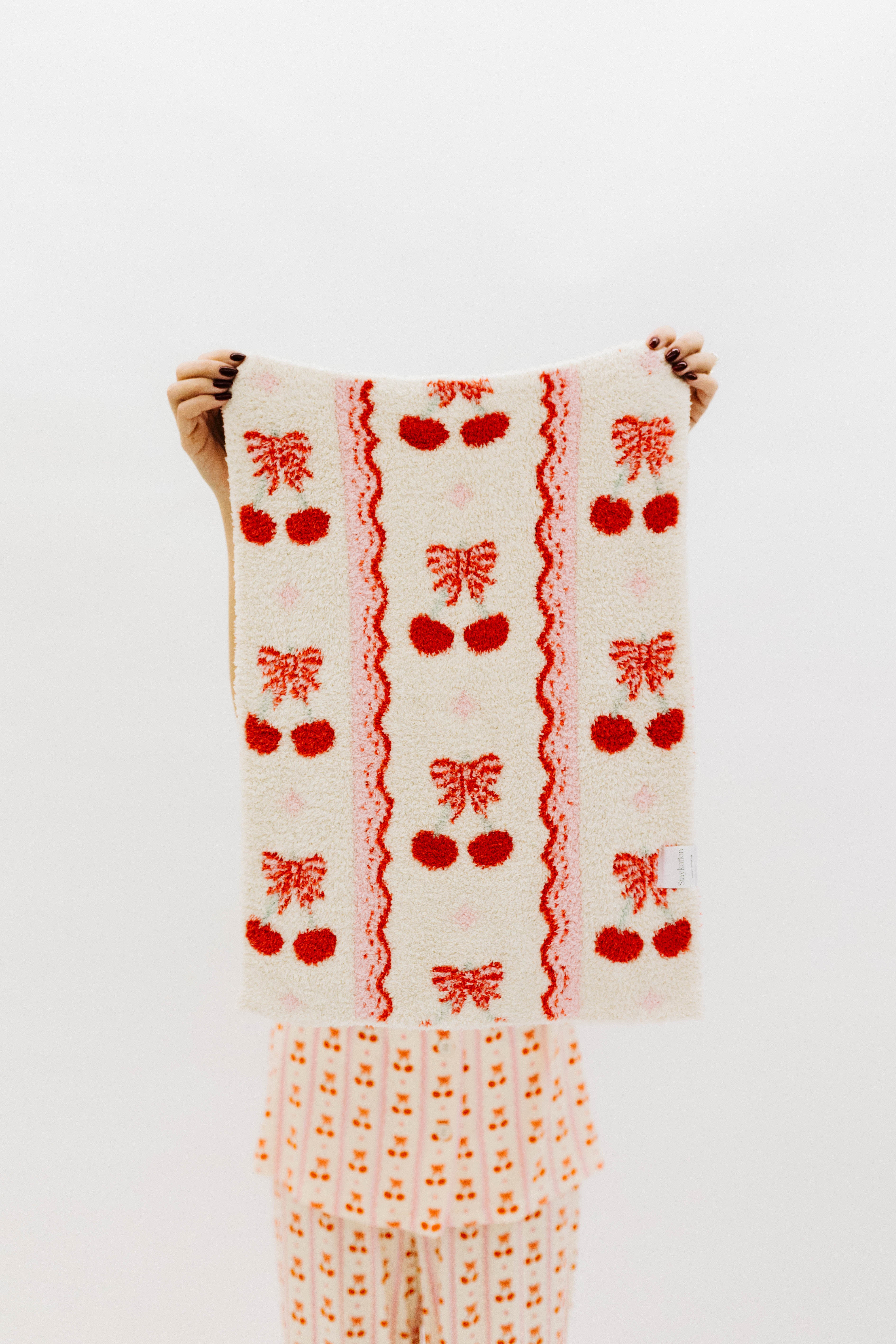 Hodling up the front of the lovey showing the cherries and bows