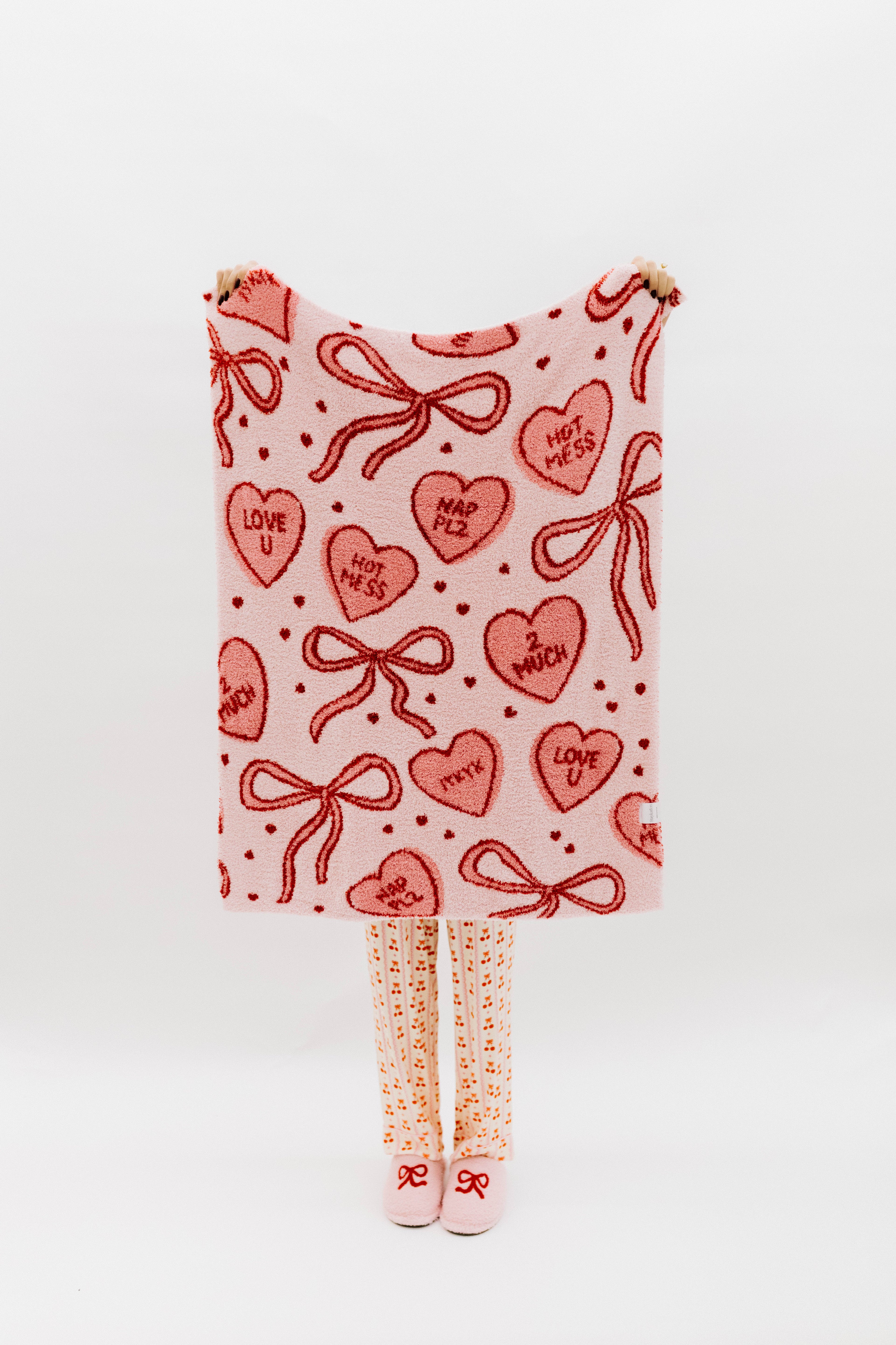 Blanket with red heart and bow pattern on a white background