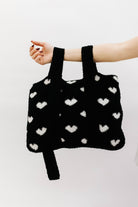 holding the back and  white quillow by the backpack straps
