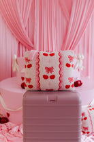 cherry quillow styled on a beis suitcase