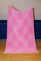 Back of the volleyball blanket showing the white bows and darker pink volleyball coming through