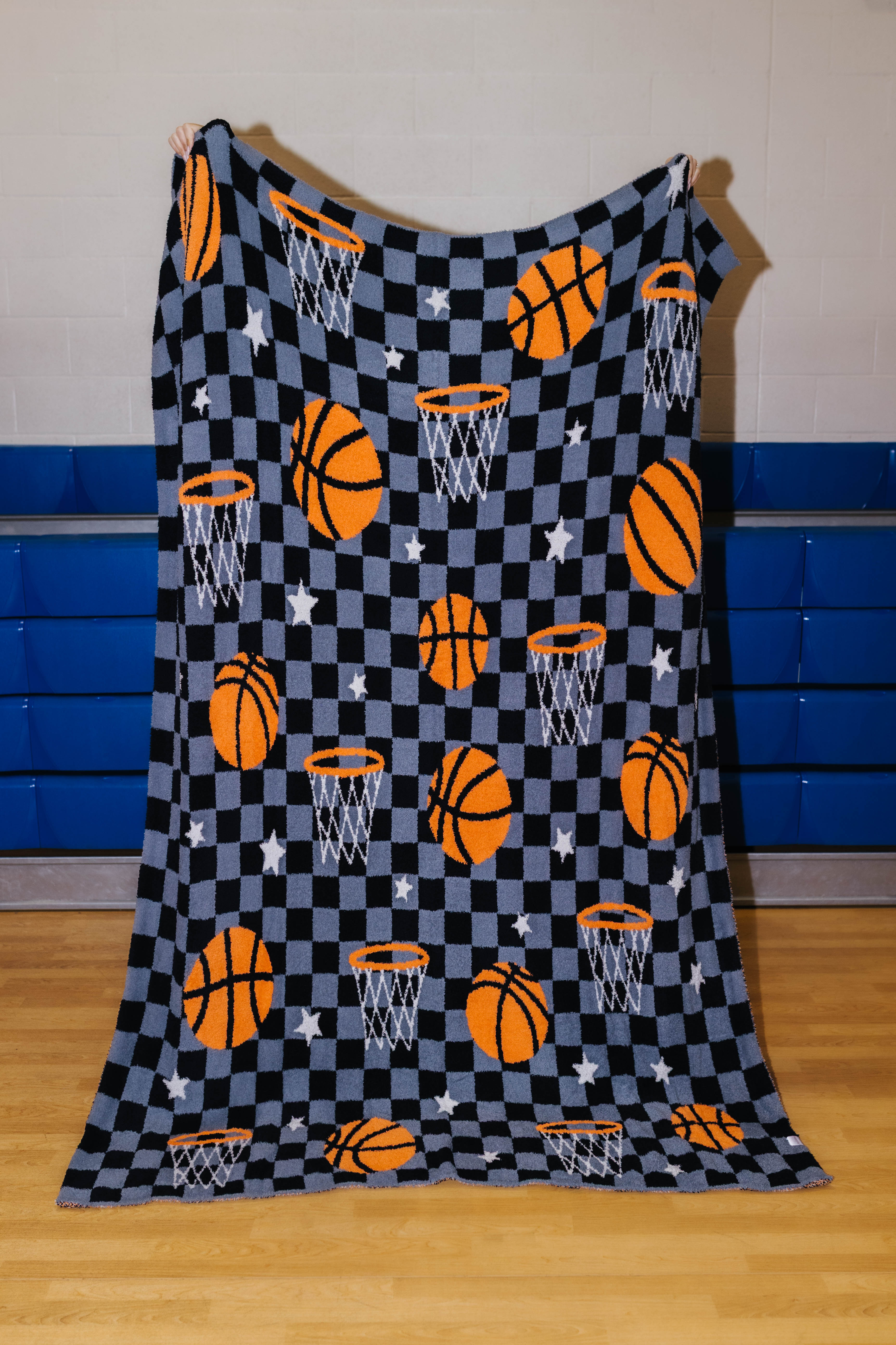 front of basketball blanket that has basketball, stars, hoops, and black/grey checkers