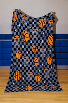 front of basketball blanket that has basketball, stars, hoops, and black/grey checkers
