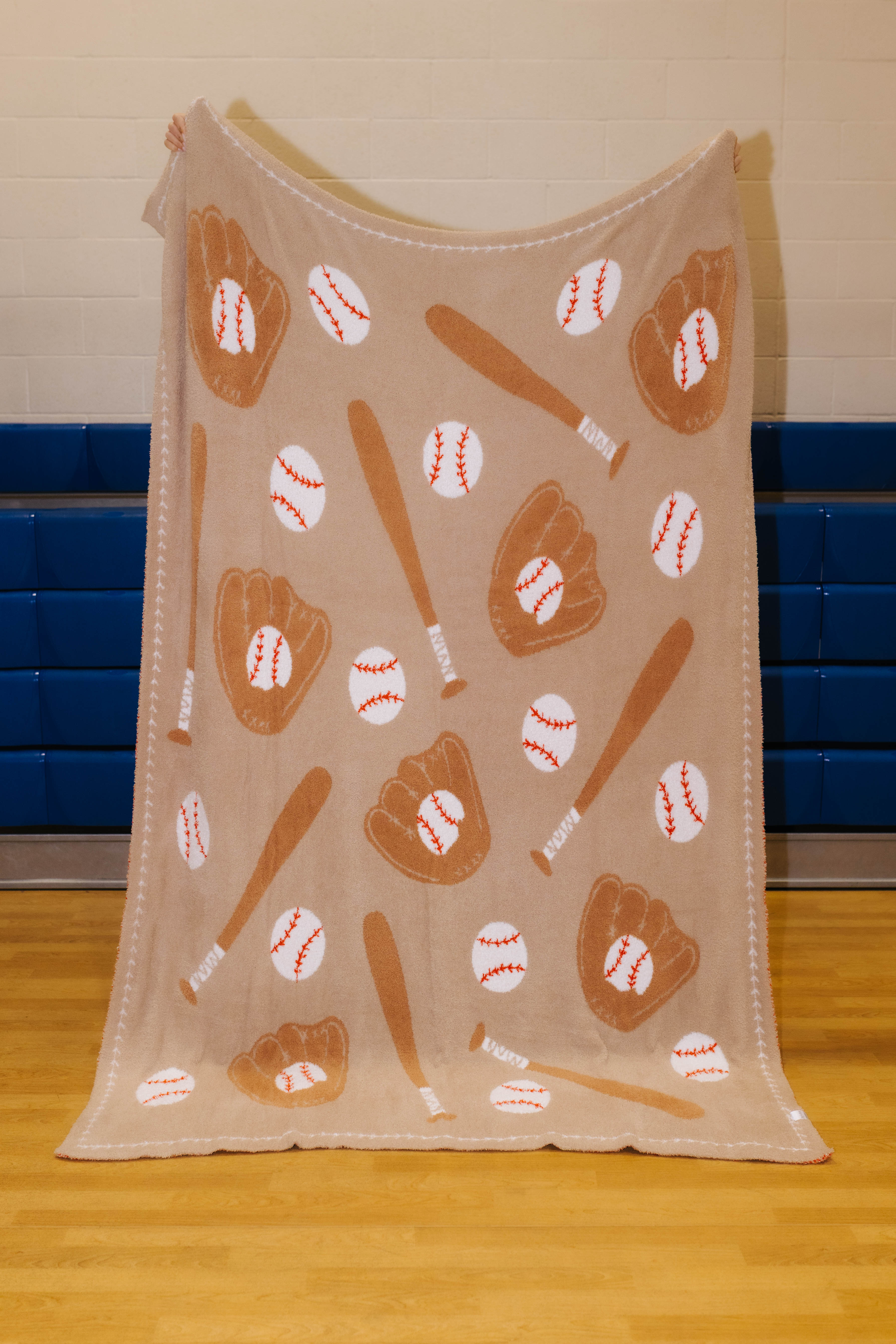 Front of baseball blanket with bats, glove, and balls - tan background and darker brown accents with white balls