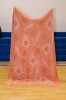 back of the baseball blanket showing mostly red and tan background