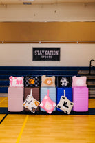 A row of colorful hard-shell suitcases and sports quillows