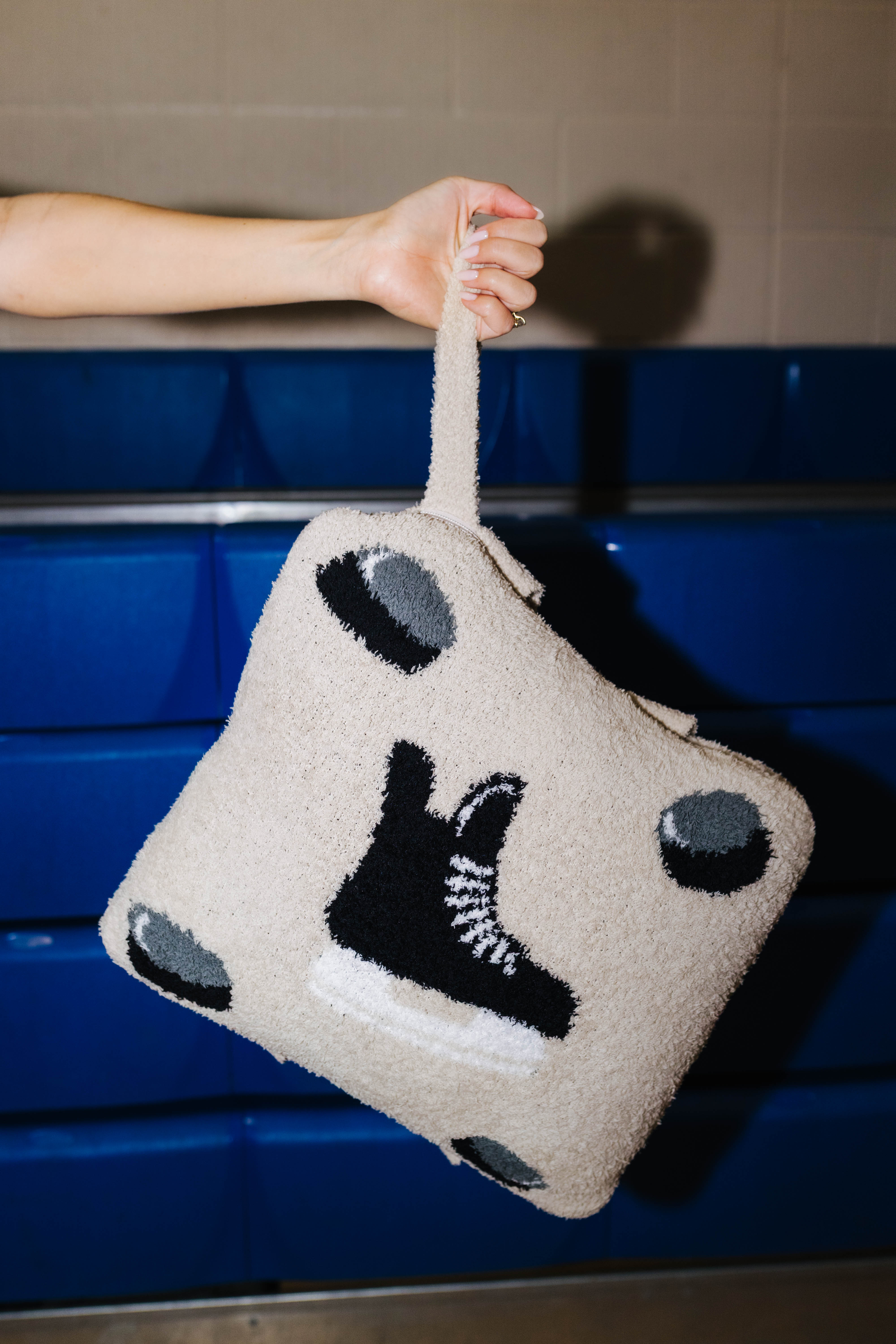 Holding the hockey quillow by the wristlet strap.