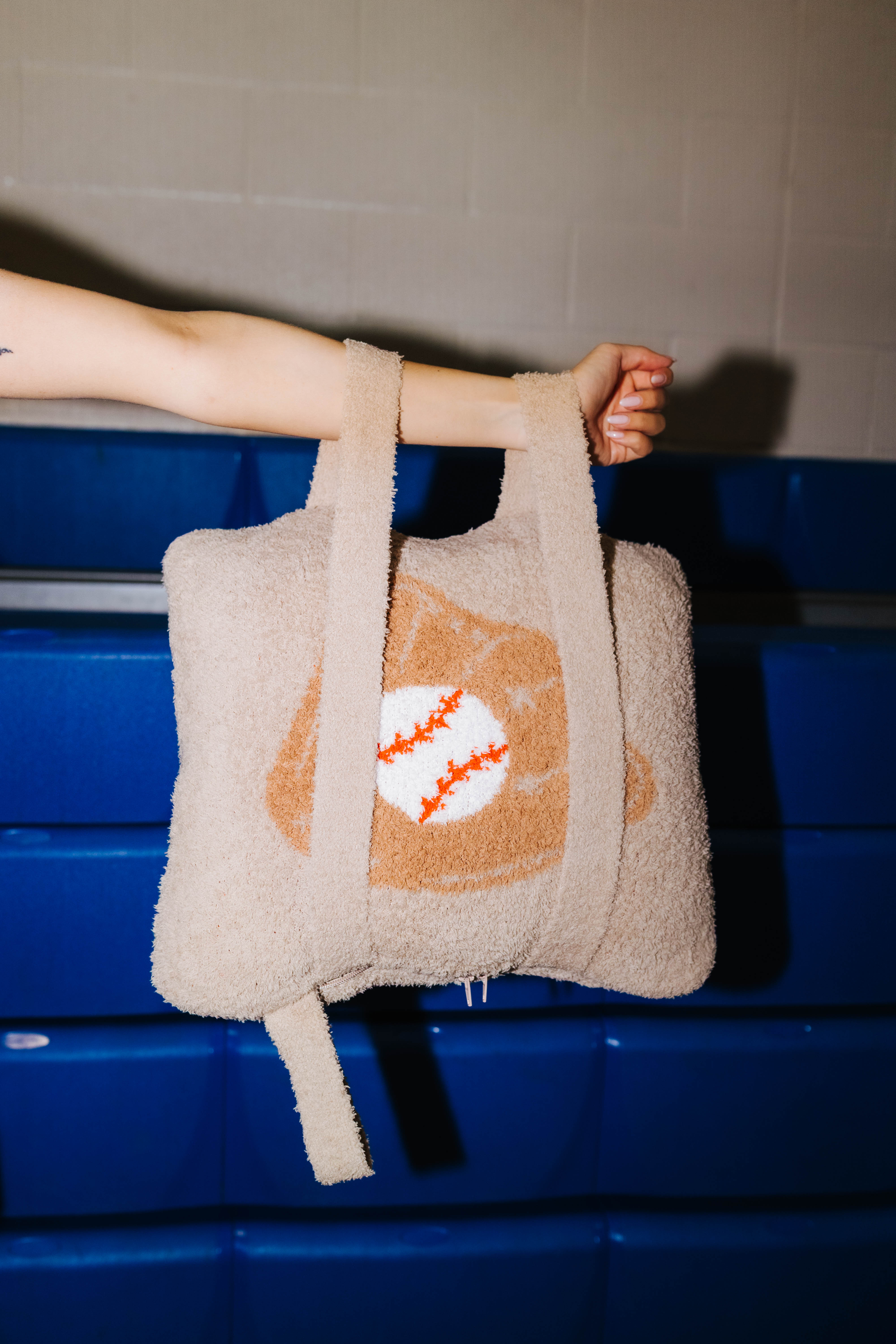 Holding the quillow by the arm showing the backpack straps