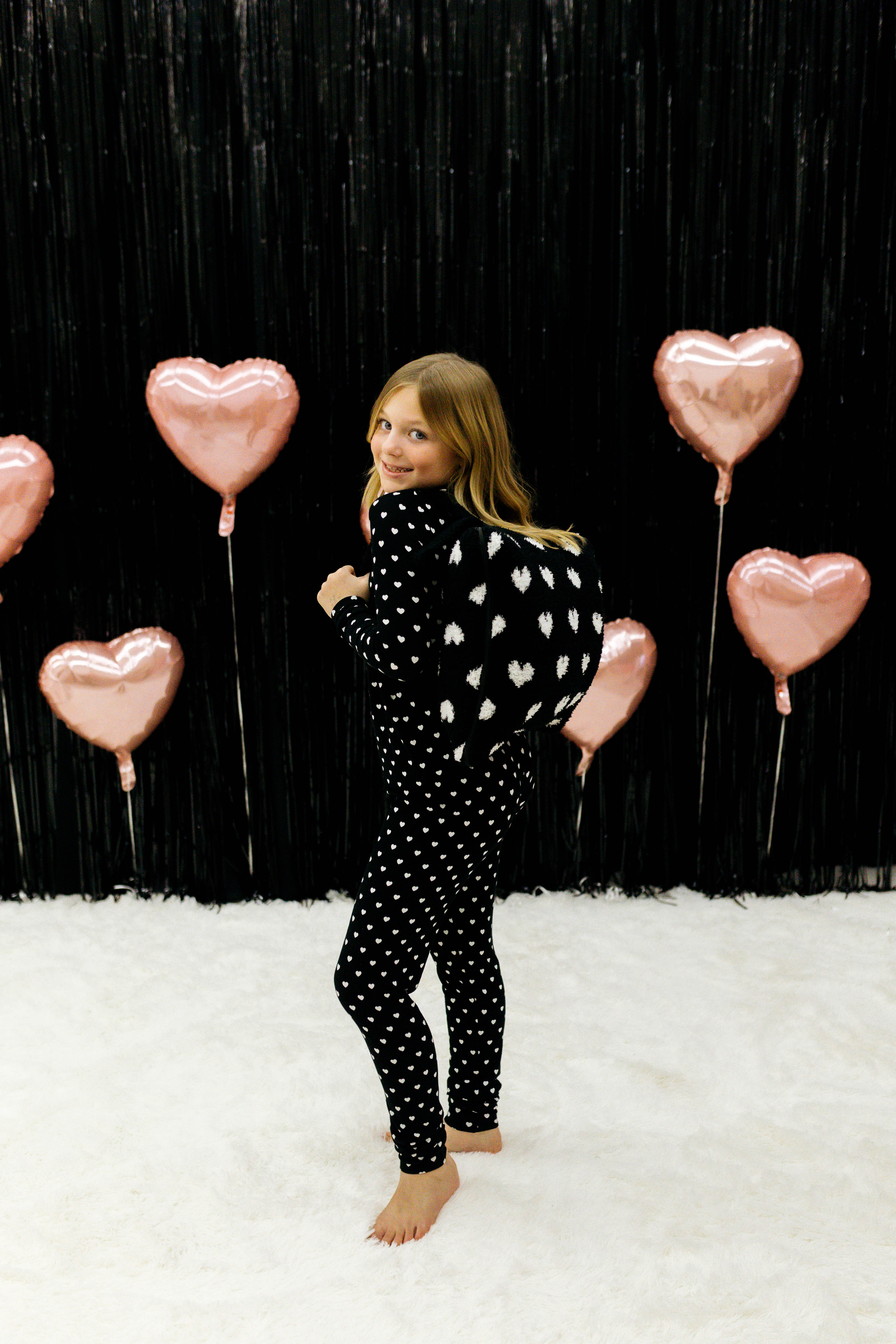 Little girl with the backpack heart quillow on her back 