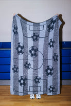 Back of the blanket showing the outline of the soccer balls and fields - mostly black and gray