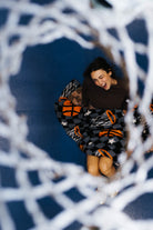 Girl under the basketball net wrapped in the basketball blanket