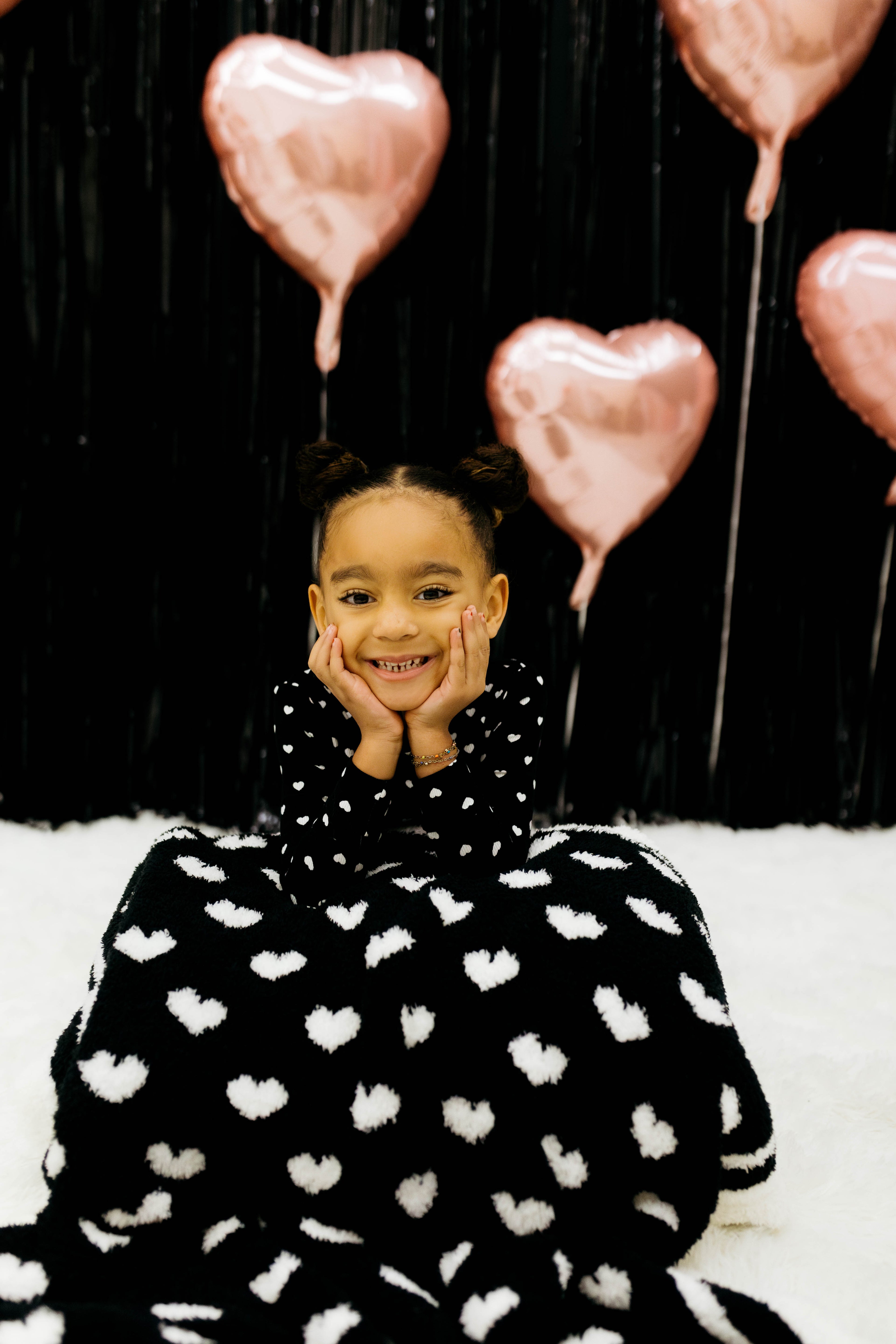 Child with the black side of the blanket draped on her lap