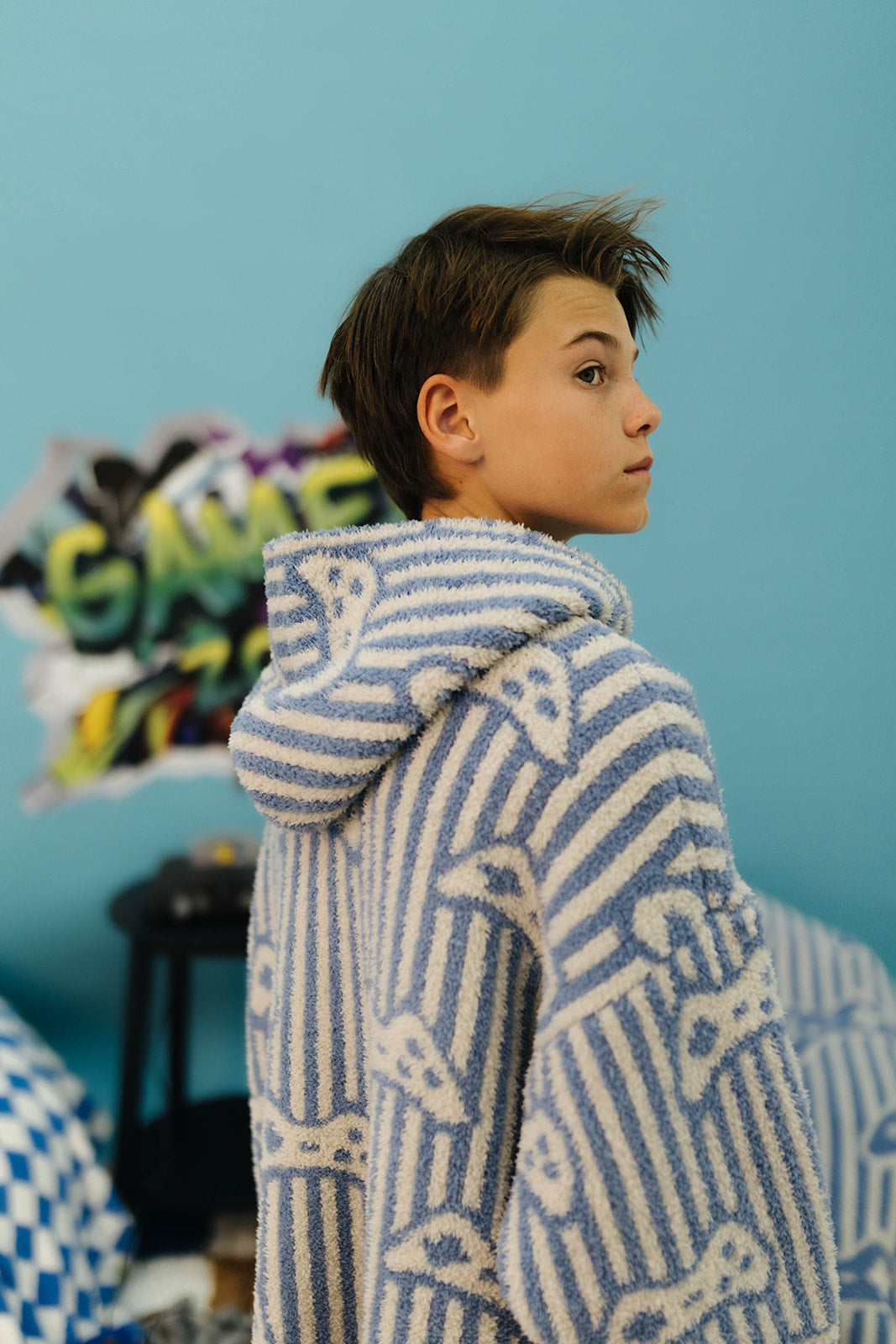 Child wearing a blue and white patterned sweater against a blue background