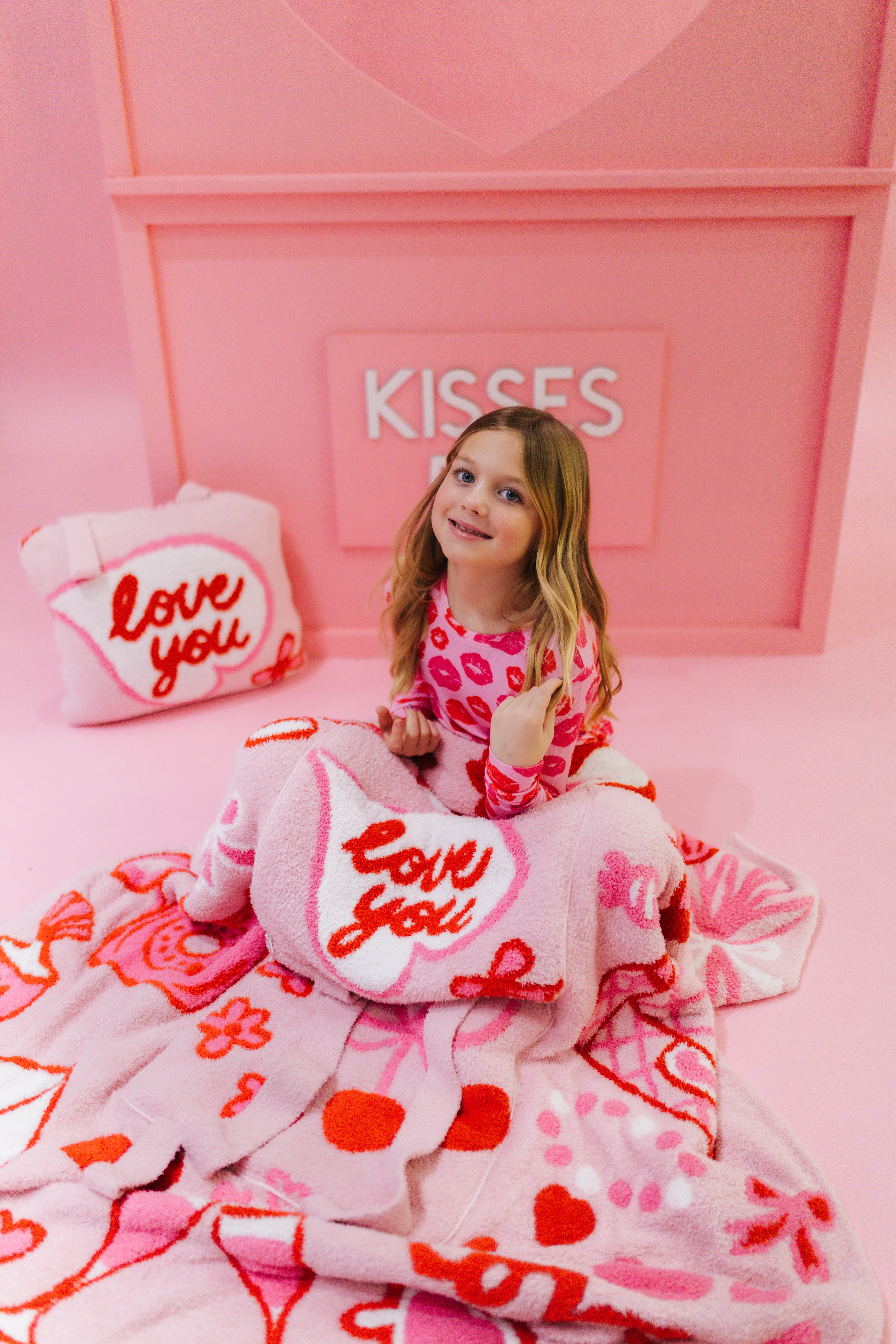 Young girl showing the 'love you' quillows.