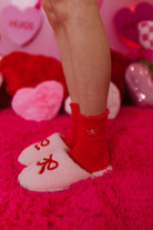 slippers and red socks on a pink rug