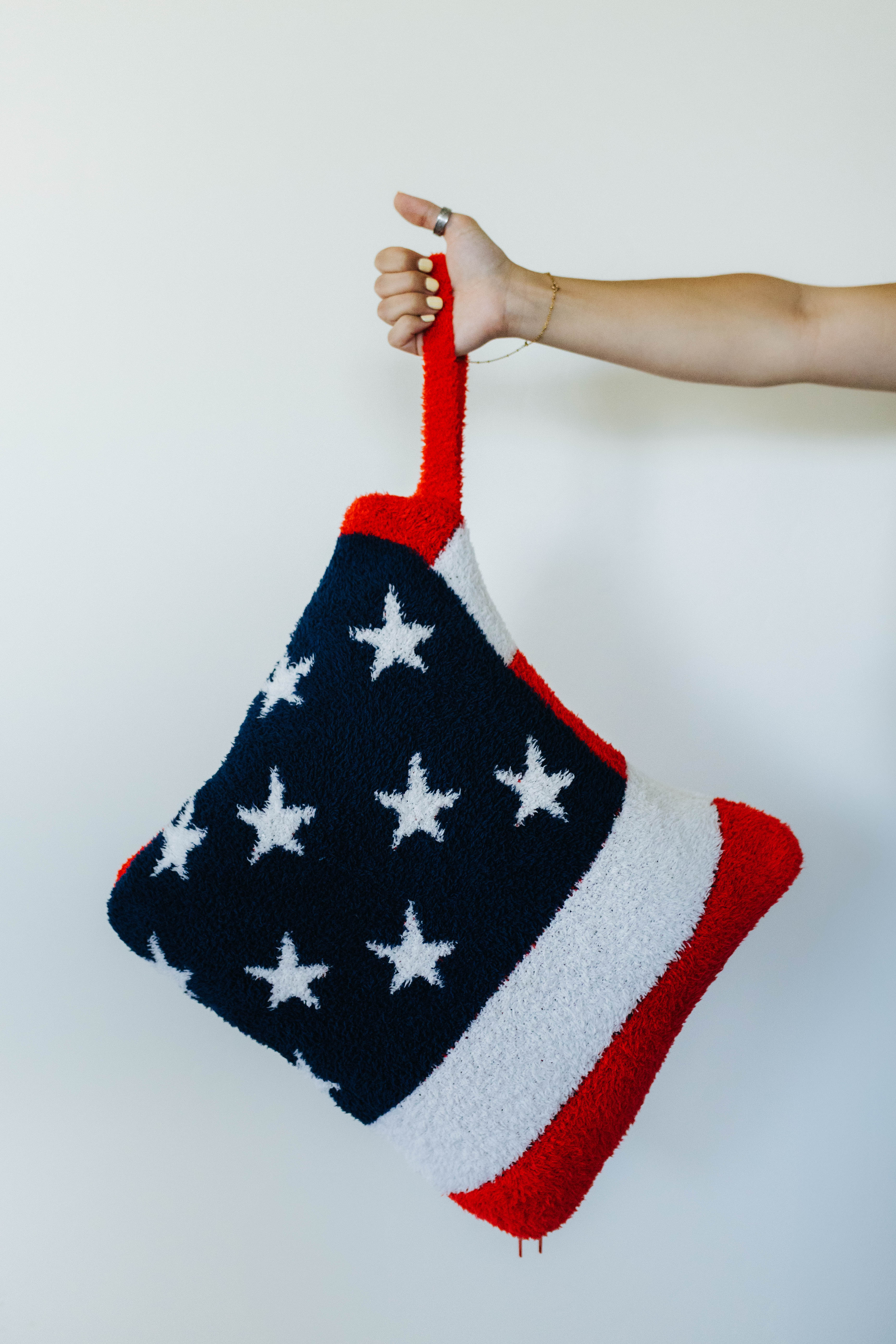 American flag quillow folded up with someone holding it 
