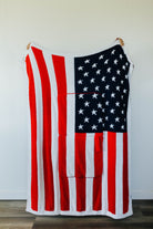 American flag quillow unfolded hanging against a white wall