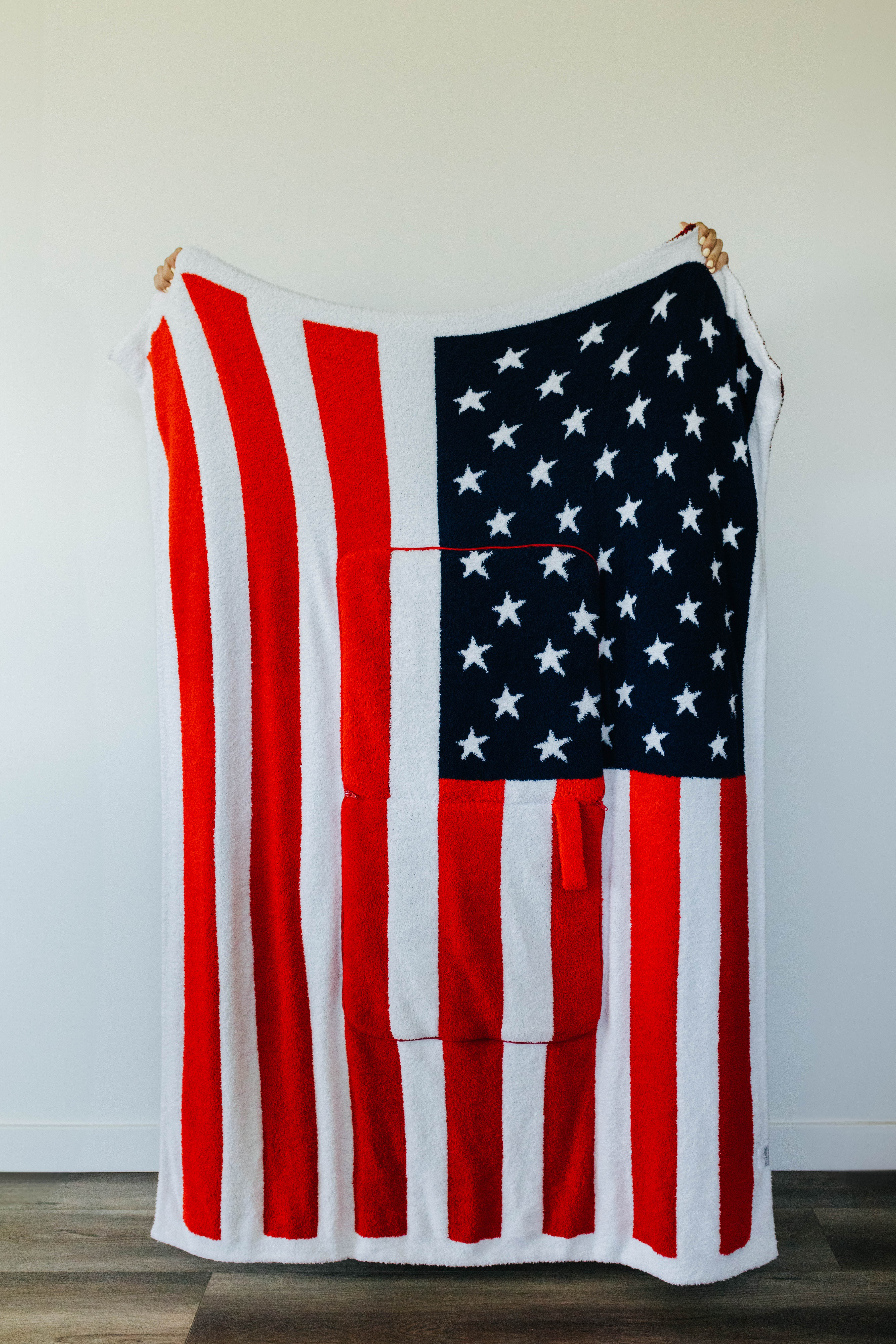 American flag quillow unfolded hanging against a white wall