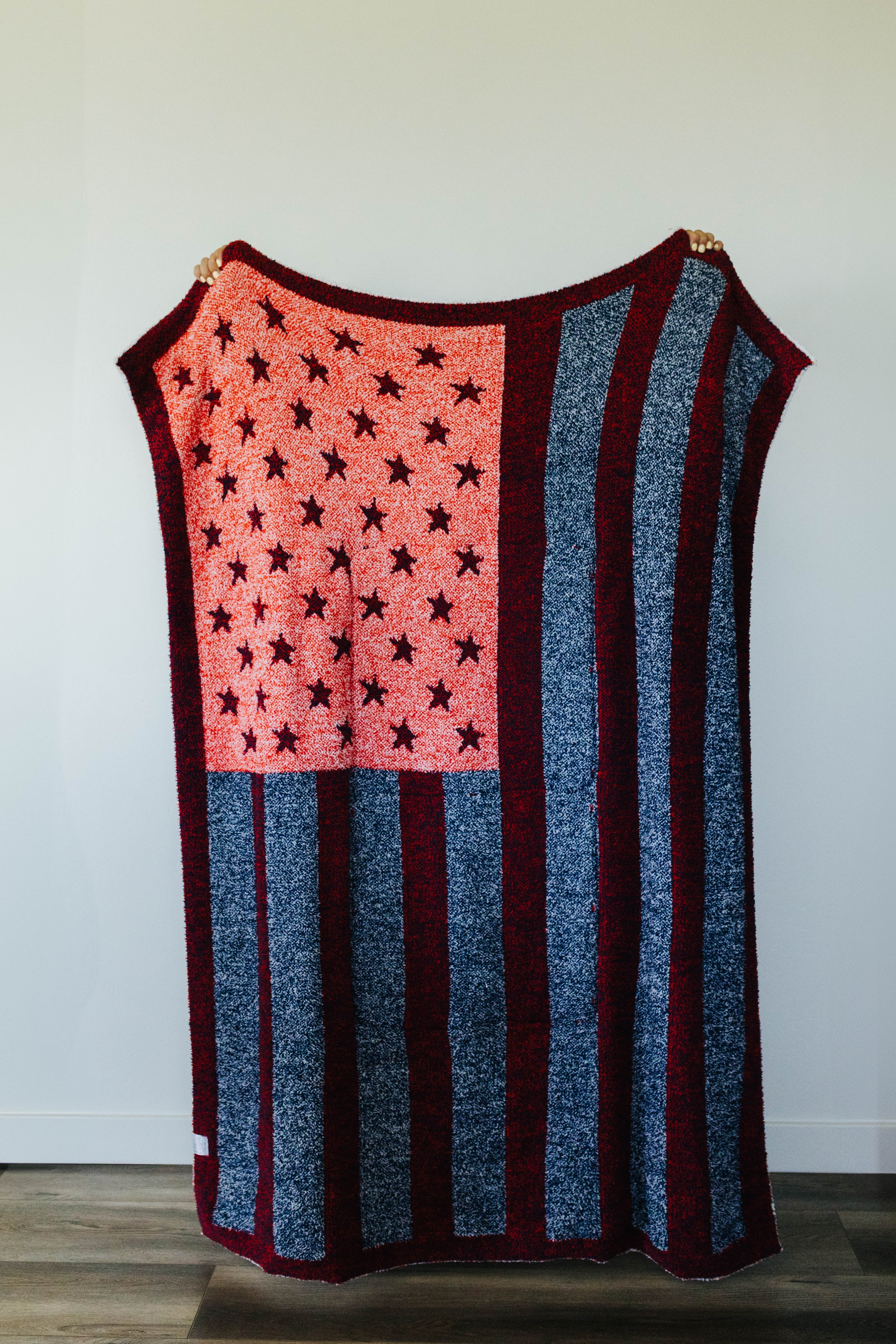American flag quillow unfolded hanging against a white wall- back side