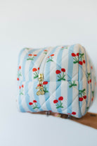 Quilted pouch with cherry pattern on a white background