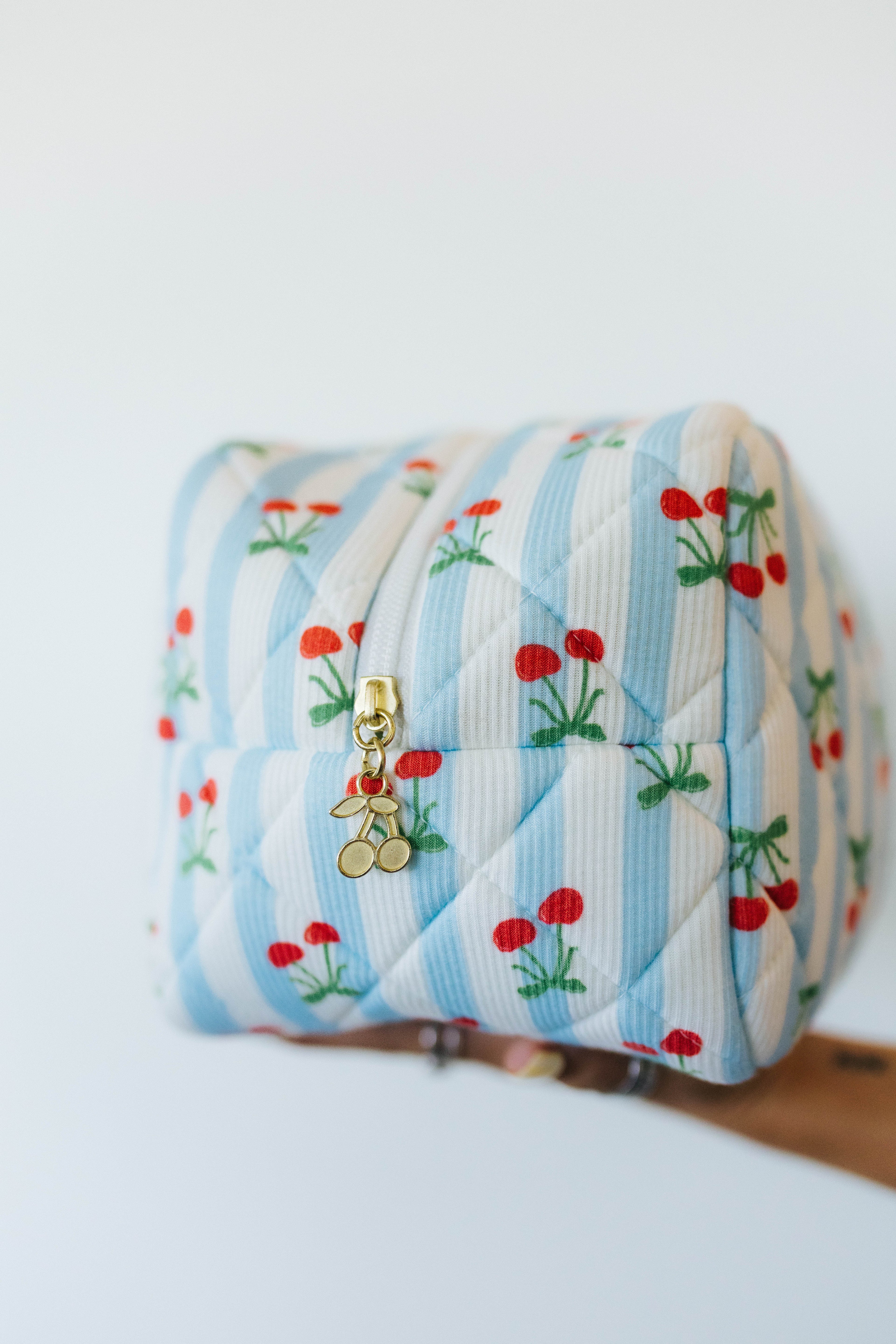 Quilted pouch with cherry pattern on a white background