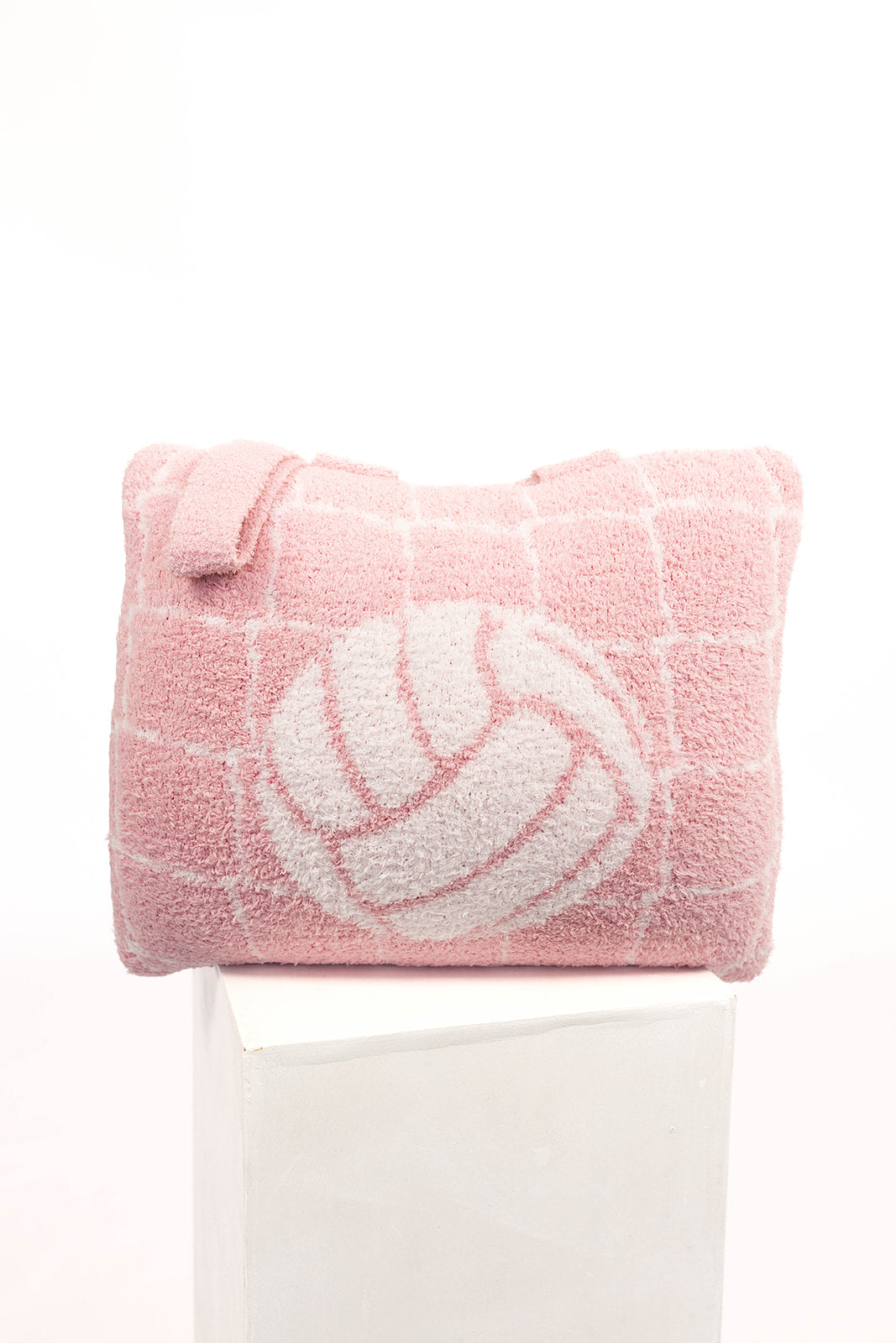 Pink quillow with a white volleyball design on a white background