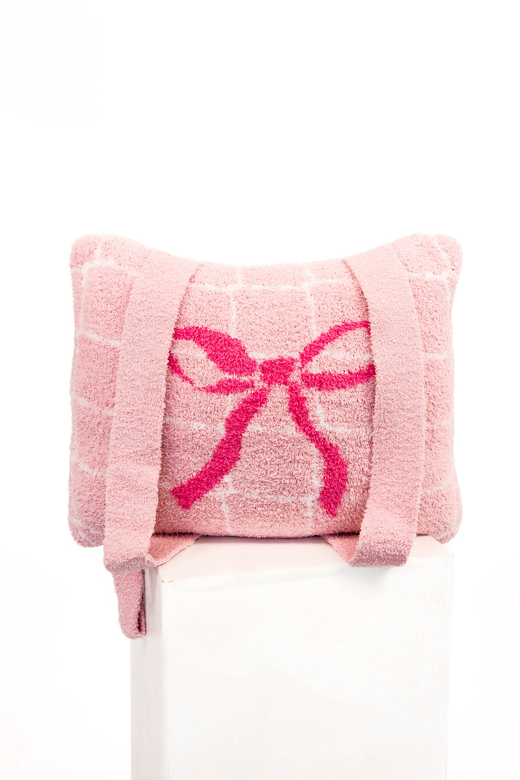 Pink quillow with a large pink bow on a white background