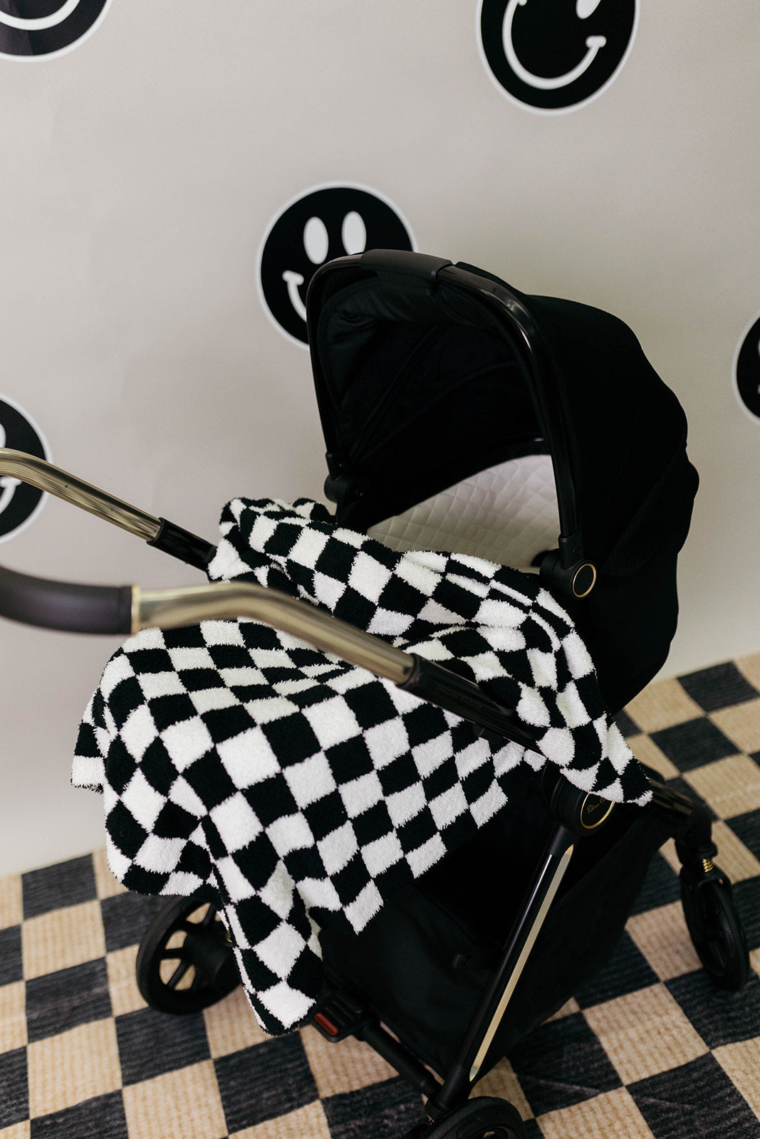 Black and white checkered blanket draped over a stroller.