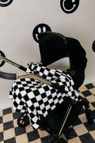 Black and white checkered blanket draped over a stroller.