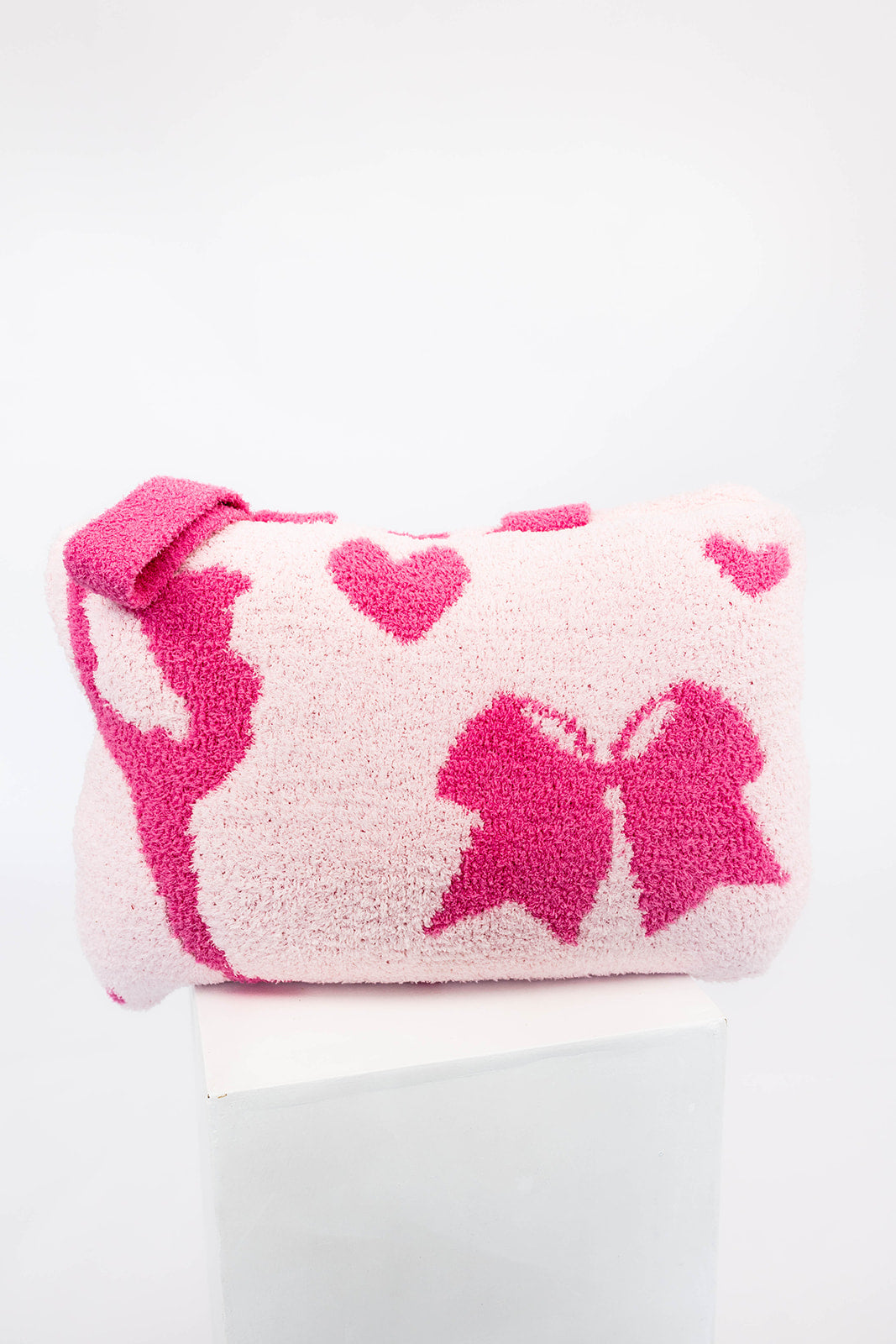 Pink and white quillow with a bow design on a white background