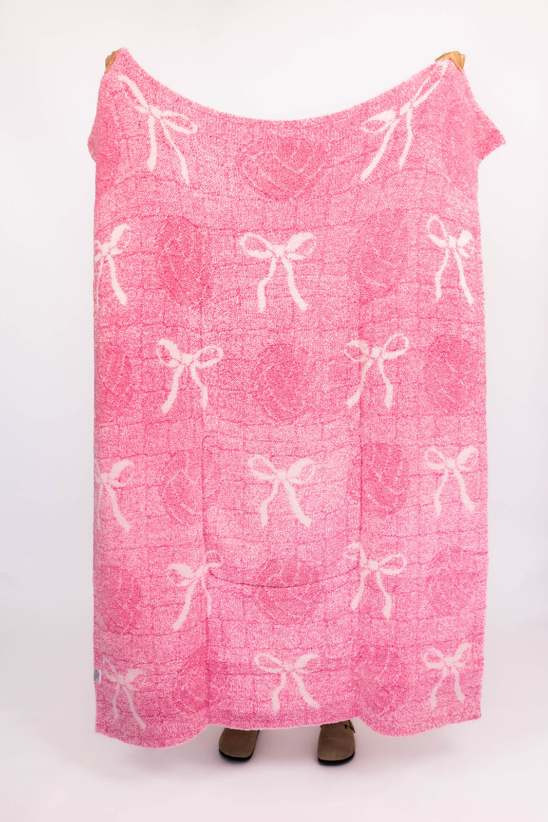 Pink blanket with white bow pattern and volleyballs on a white background